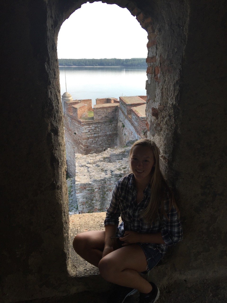 views of the fortress wall and Danube river through a narrow rounded window