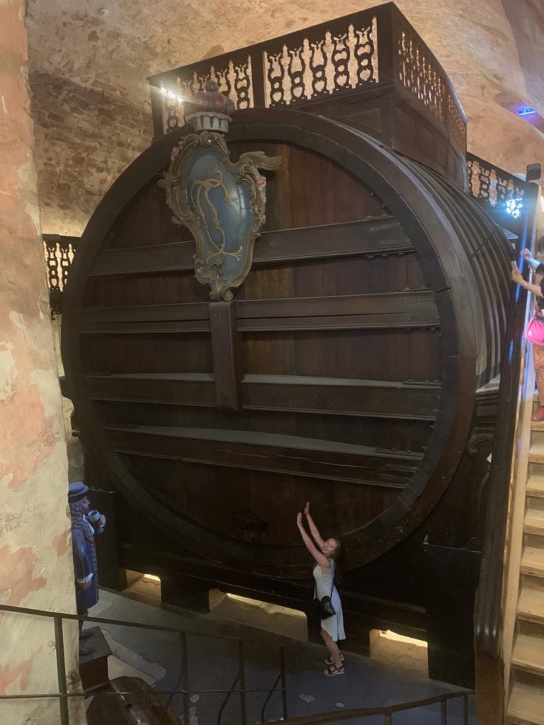 Maddie dwarfed by the Heidelberg Tun a giant wine barrel at Heidelberg Castle