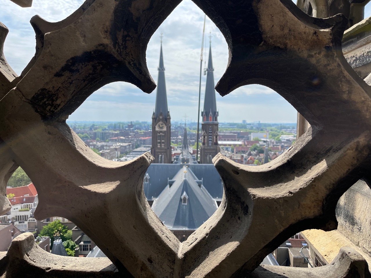 twin church towers through the decorative railing of the New Church of Delft tower