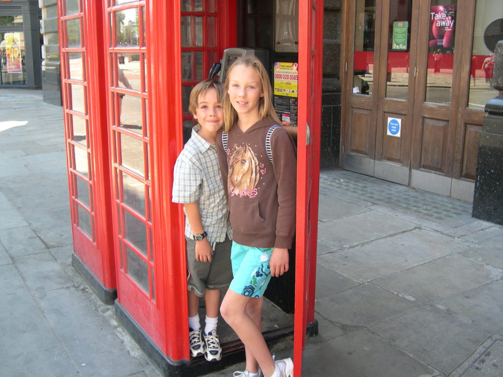 Young Maddie and brother in a phone box in London