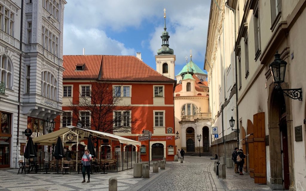 street in Prague with red and white buildings and a tower