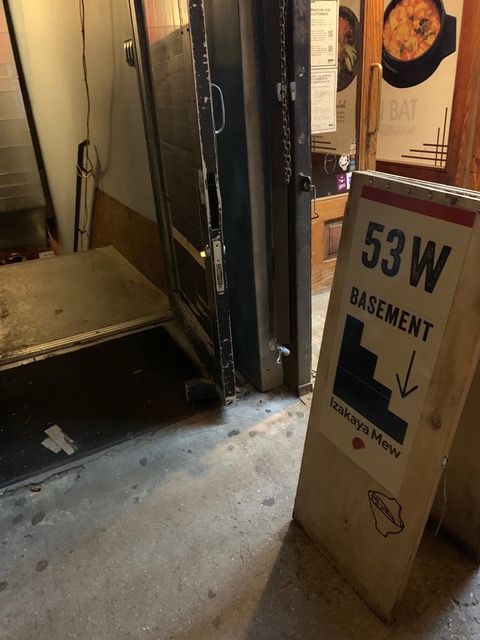Sign, cement, and narrow metal stairs on a New York Stree