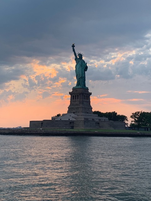Statue of Liberty with peach colored clouds behind