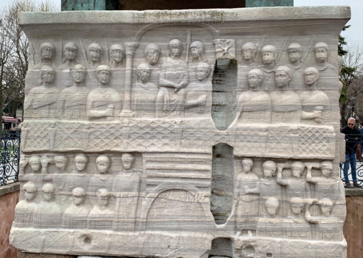 White base of the obelisk carved with rows of people