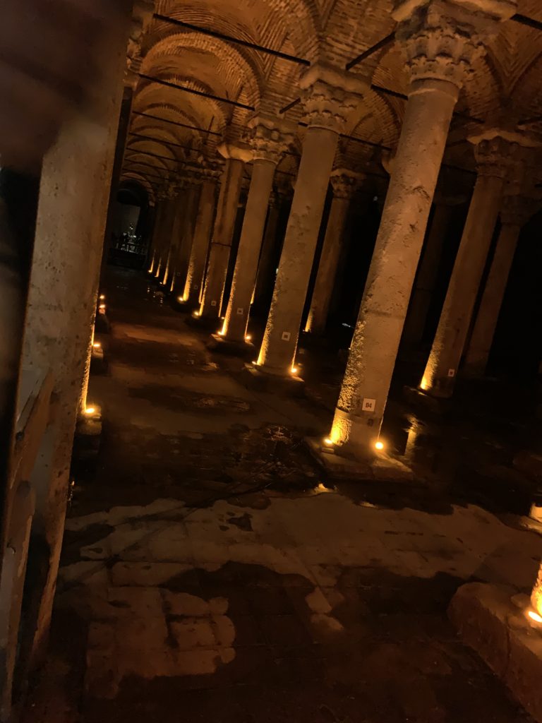 dimly lit row of columns over a damp floor