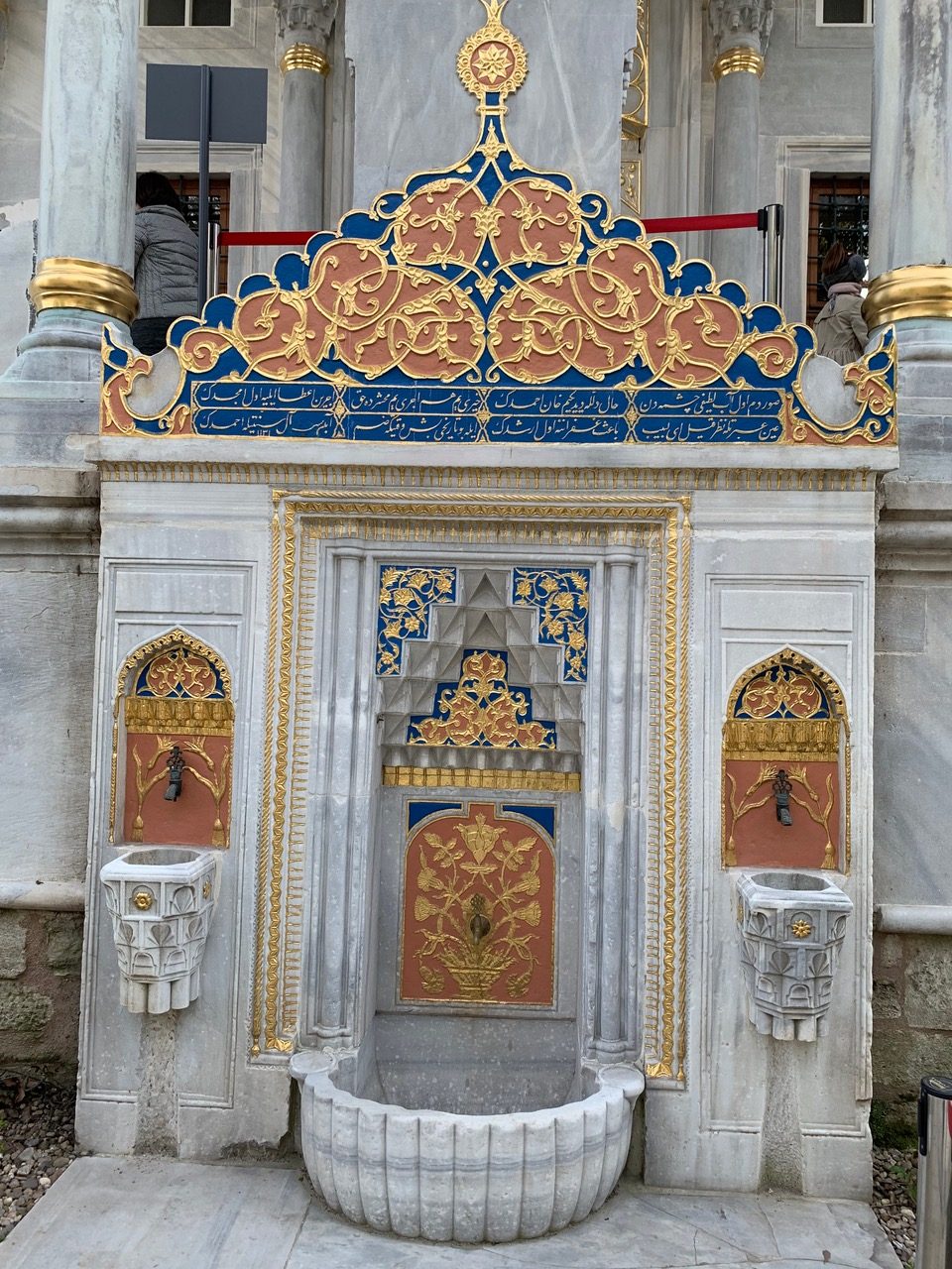 marble and gilt wall fountain inlaid with blue, gold, and orange
