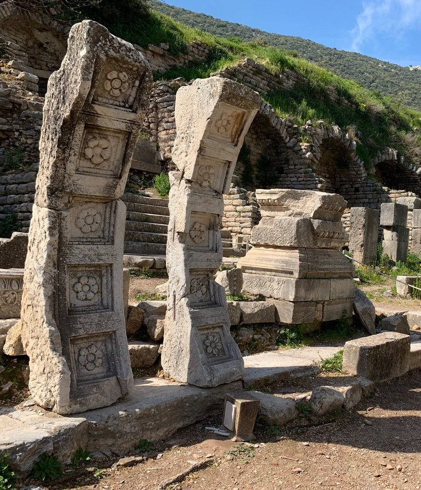 Stone slabs stacked into a curve and decorated with carved six petaled flowers