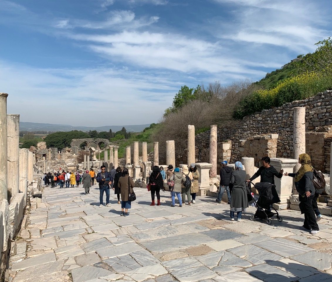 The main road of Ephesus with marble blocks and half reconstructed columns full of people as it once might have been