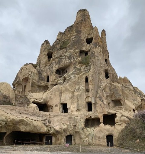 towering piece of tufa with door ands windows carved out in a haphazard fashion