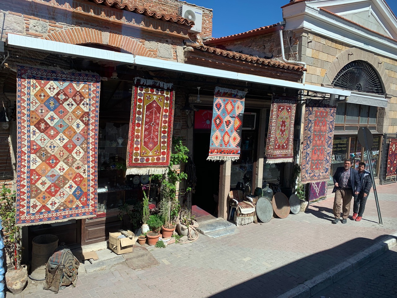 rugs hanging in front of a shop in Pergamum