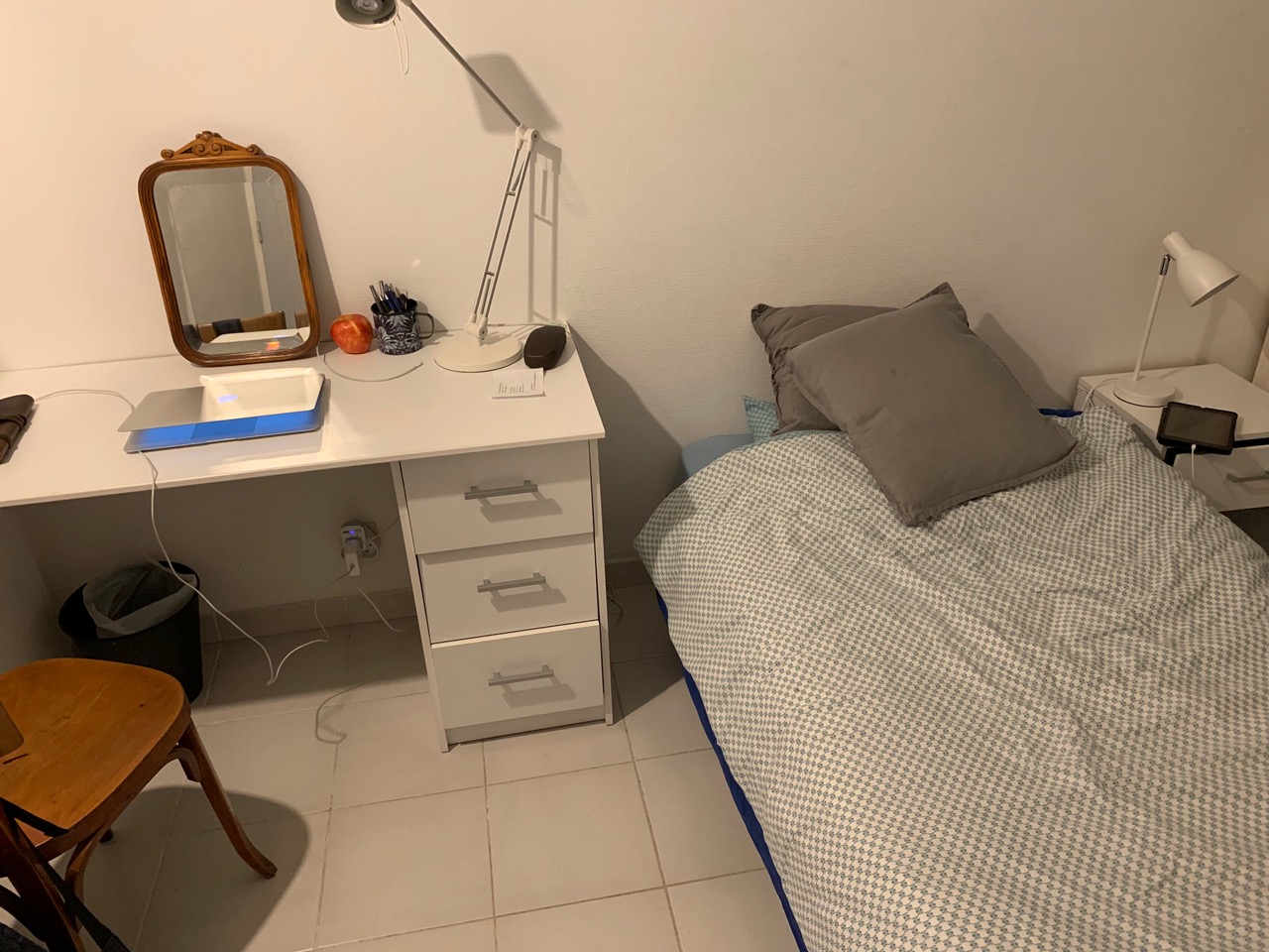 My temporary bedroom: a narrow bed, desk with a mirror and chair