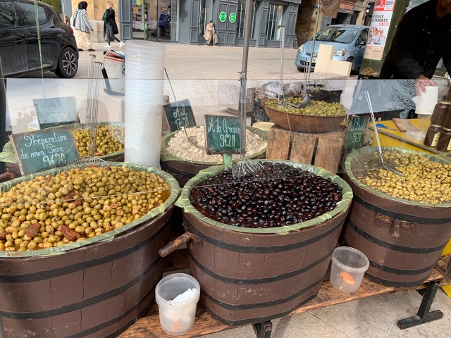 open topped barrels of olives at the market
