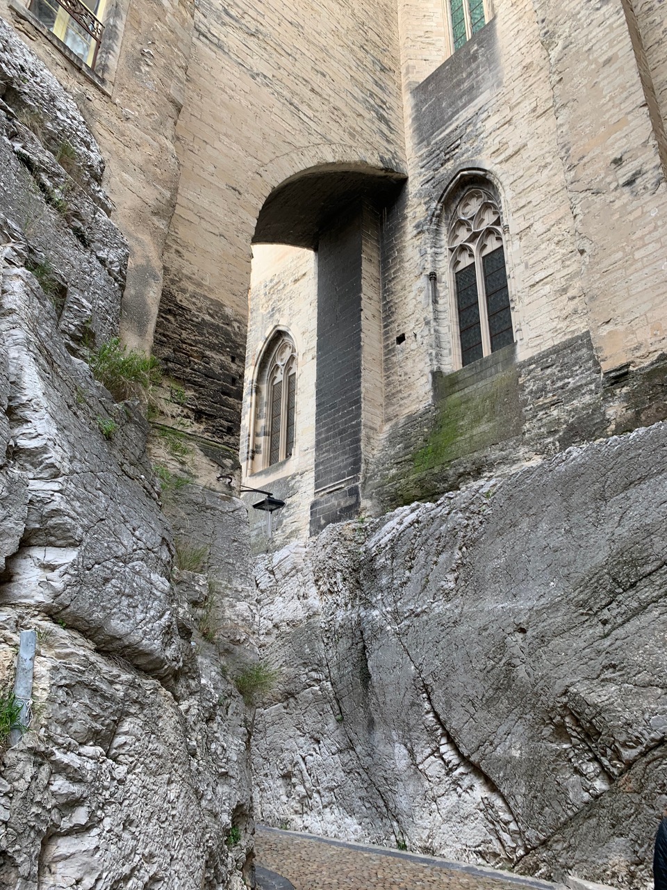 The palace of the popes built into the bedrock with an arch across a narrow street