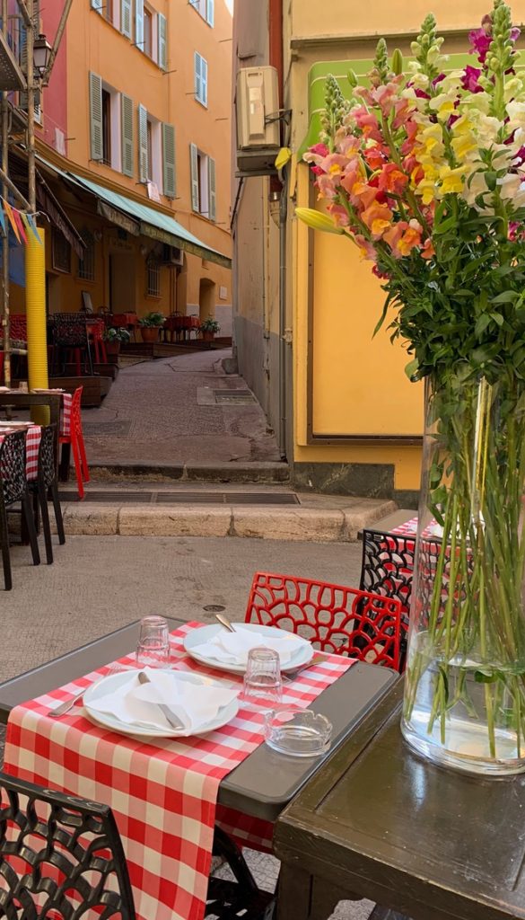Checkered table cloth and bouquet of flowers on a narrow street in Nice France