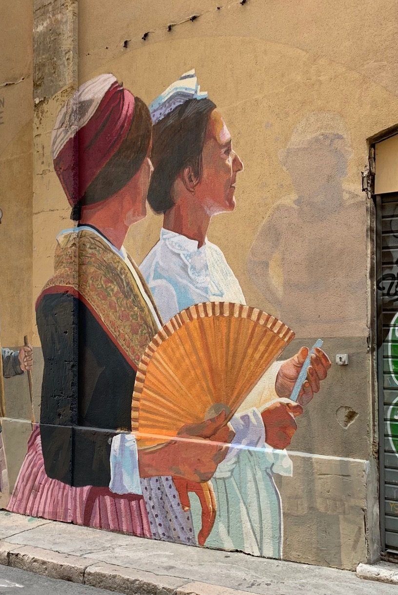 Two painted women with fans and dresses