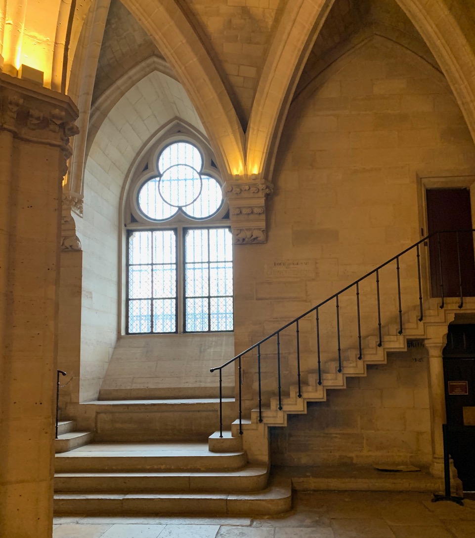 Narrow staircase beside a gothic window