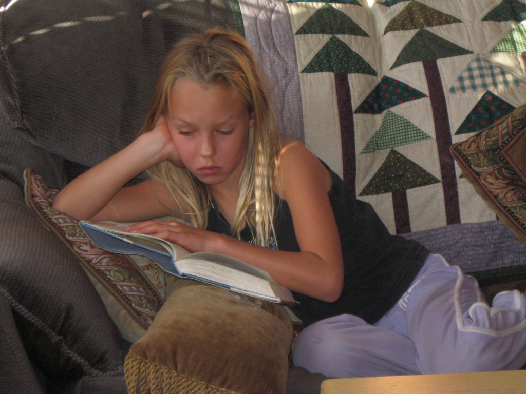 Young Maddie reading on a sofa