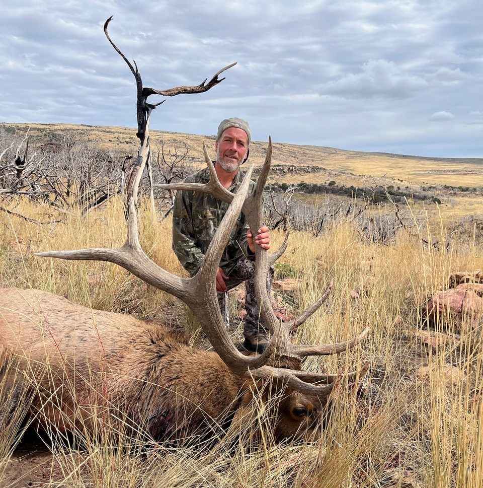 Charlie Kunkel smiles over his dead bull elk in 201